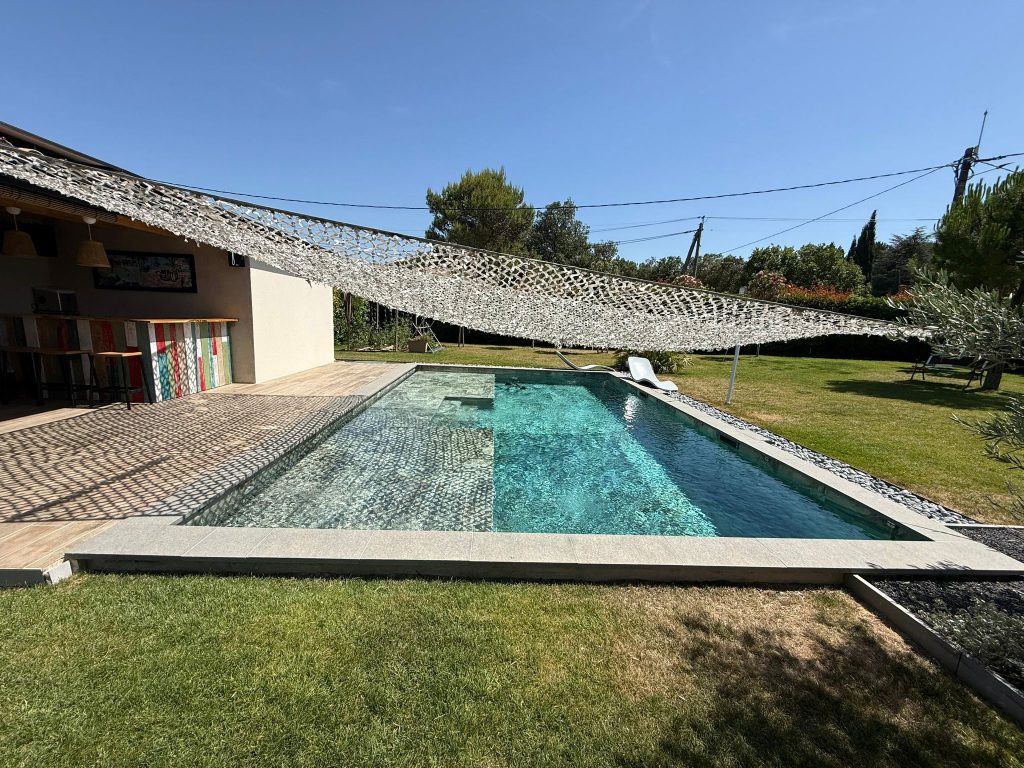 Piscine béton Reflets d’ici, terrasse bois et jardin méditerranéen